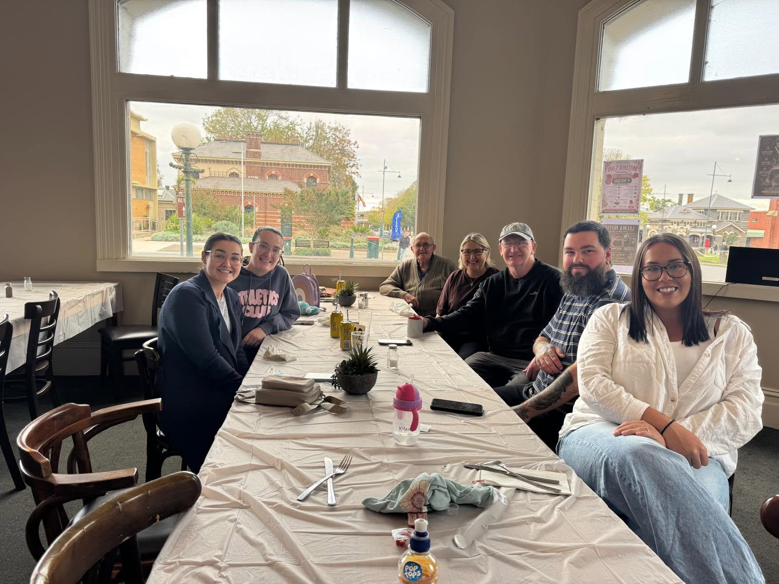 A family group sharing lunch by the bistro windows