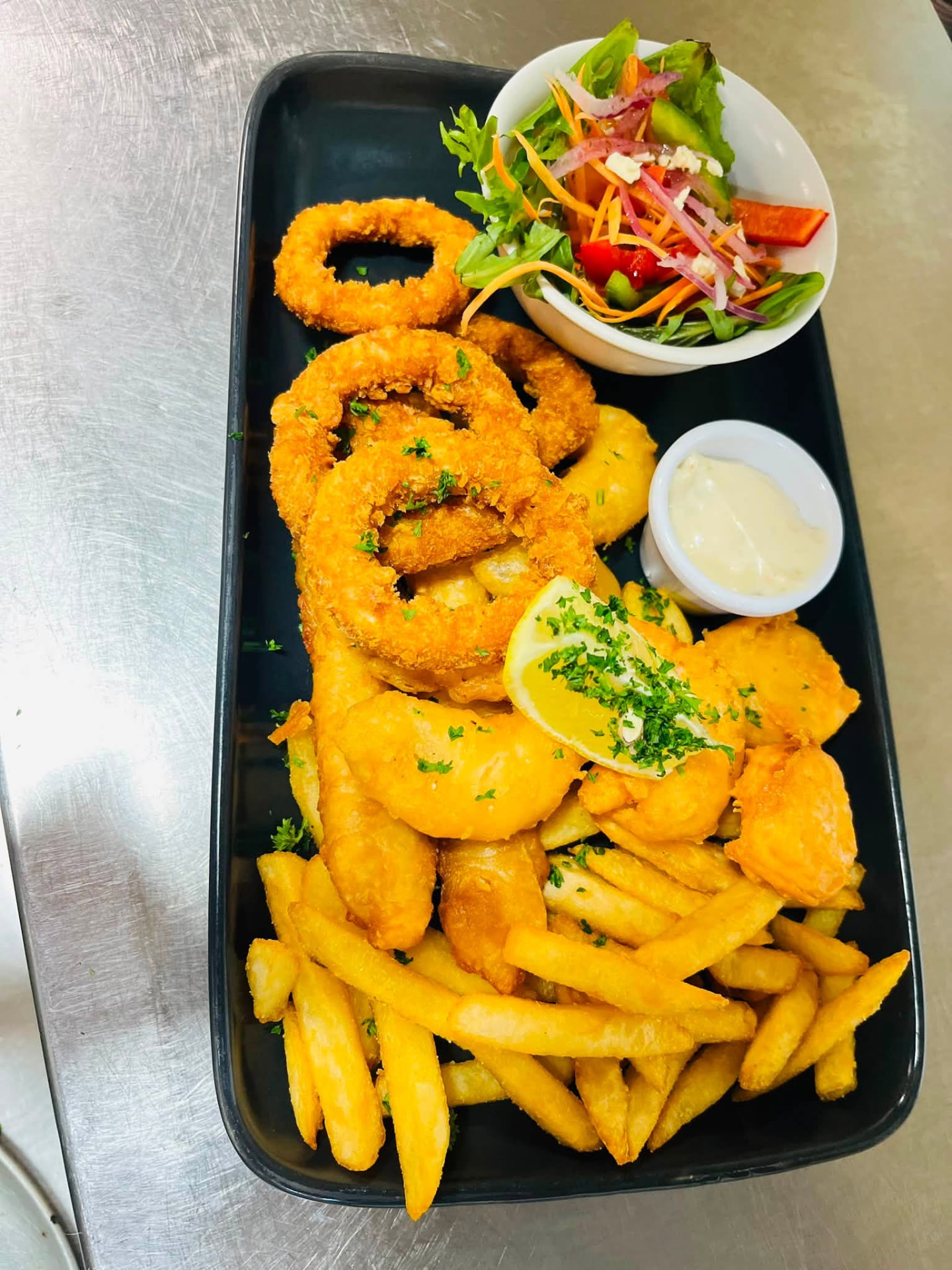 Seafood basket with calamari rings, fish, chips and salad