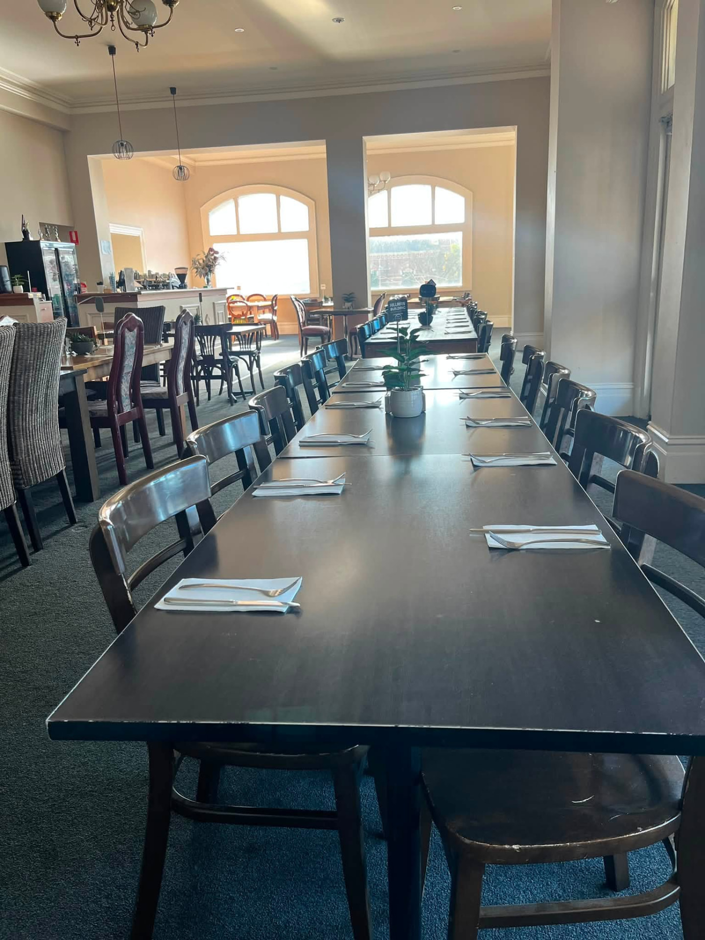 Sunlit dining room with long tables ready for guests